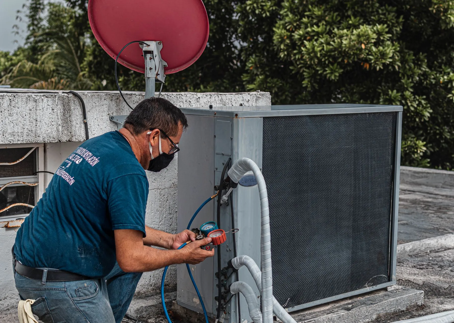 AC technician repairing an outdoor air conditioner unit in Jeddah